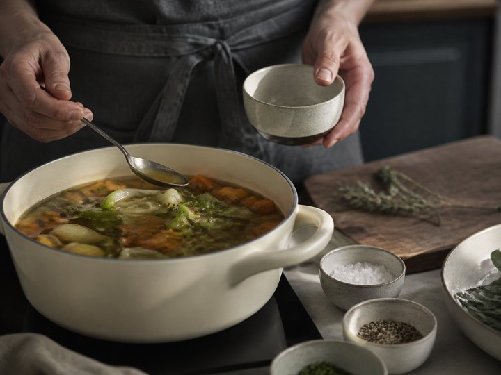 A cook tasting and seasoning a vegetable broth